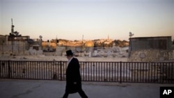 An ultra-orthodox Jewish man walks near the Dome of the Rock Mosque in Jerusalem's Old City, 22 Nov 2010