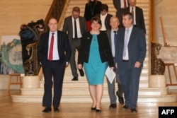 Leader of the Democratic Unionist Party (DUP) Arlene Foster (C) arrives to speak to the media with her deputy leader Nigel Dodds (L) along side at the Parliament Buildings on the Stormont Estate in Belfast on Feb.12, 2018.