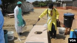 An official disinfects a bed for patients at a temporary shelter in Harare, Sept. 12, 2018, where suspected cholera patients are being treated. (C. Mavhunga/VOA)