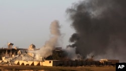 Smoke rises from buildings in central Tikrit, Iraq, during clashes between Iraqi security forces and Islamic State group extremists in the city, north of Baghdad, March 26, 2015.