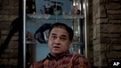 In this Feb. 4, 2013 photo, Ilham Tohti, an outspoken scholar of China's Turkic Uighur ethnic minority, pauses during an interview at his home in Beijing, China.