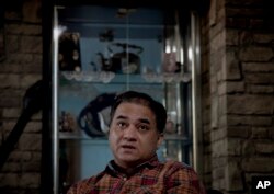 In this Feb. 4, 2013 photo, Ilham Tohti, an outspoken scholar of China's Turkic Uighur ethnic minority, pauses during an interview at his home in Beijing, China. Tohti was set to go on trial on separatism charges on Wednesday, Sept. 17, 2014.