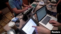 Hackers try to access and alter data from an electronic poll books in a Voting Machine Hacking Village during the Def Con hacker convention in Las Vegas, July 29, 2017. 