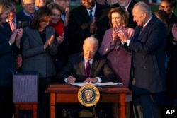 President Joe Biden signs the "Infrastructure Investment and Jobs Act" during an event on the South Lawn of the White House, Nov. 15, 2021.