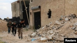 FILE - Free Syrian Army fighters run with their weapons during clashes with forces loyal to Syria's President Bashar al-Assad at the Karam Barre front line in Aleppo, Nov. 2, 2014. 