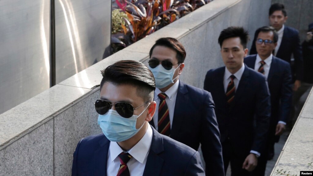 Des policiers de Hong Kong arrivent au tribunal de district de Hong Kong, le 14 février 2017, alors qu'ils étaient accusés d'avoir agressé un militant en faveur de la démocratie lors d'un incident le 15 octobre 2014. AP / Kin Cheung