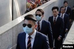 FILE - In this Feb. 14, 2017 file photo, five of the seven Hong Kong police officers arrive the District Court in Hong Kong as they were charged with assaulting a pro-democracy activist in an incident on Oct. 15 2014.