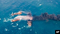 FILE - Firefighting boats work to put on a blaze on the oil tanker Sanchi in the East China Sea off the eastern coast of China, Jan. 10,2018.