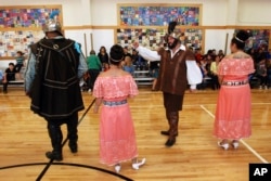 Edwin Quintana, second from right, motions to a crowd of students at Tesuque Elementary school in Tesuque, N.M., Aug. 30 2017. The students and others in Santa Fe's public school district were allowed to skip the annual presentation of Spanish colonial culture and history that honors a 17th century conquistador, in deference to Native American students and others who may find the performances disrespectful. None opted out in Tesuque