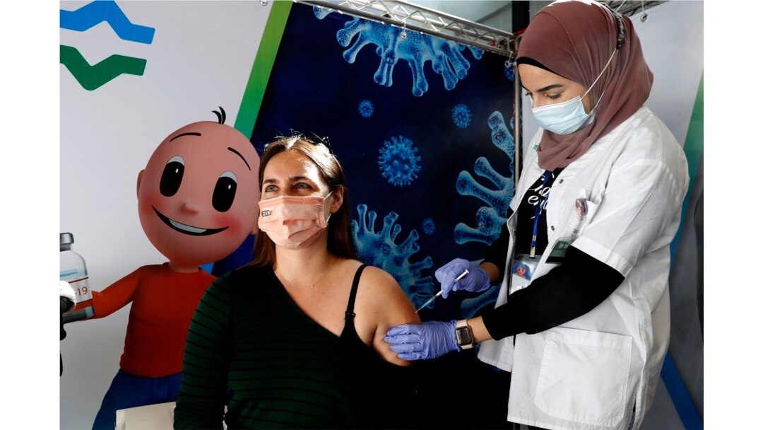 Seorang tenaga medis memberikan vaksin Pfizer-BioNtech di Petah Tikva, Israel.