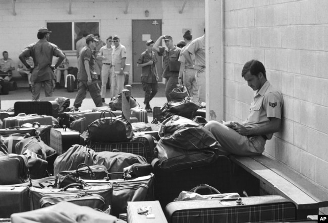 An American soldier reads a paperback book while waiting to leave Vietnam along with the last remaining U.S. military personnel in 1973.