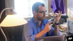 FILE - Francisco Marquez, an opposition activist in Venezuela who participated in a recall campaign against President Nicolas Maduro, works on his computer at the family home in Del Mar, California, Oct. 20, 2016.