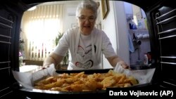  Granny's Kitchen: Jelena Petrovic places the tray with food into the oven