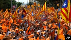 Warga Catalonia kibarkan bendera pro-kemerdekaan, yang dikenal dengan bendera Estelada, dalam sebuah reli menuntut kemerdekaan Catalonia, di Barcelona, Spanyol, 11 September 2015. 