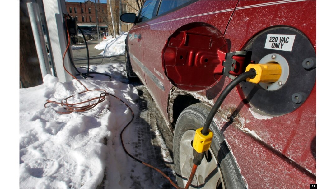 FILE - An electric car is charged in Montpelier, Vt., Jan. 18, 2013. With gas prices low, consumers are buying more trucks and SUVs and fewer fuel-efficient vehicles. That makes it harder to reach fleetwide gas mileage targets.