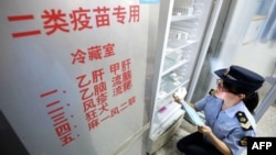 2018年7月23日，當地市場監管機構官員在中國廣西榮安一家醫院檢查疫苗。
