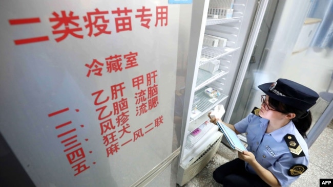 2018年7月23日，当地市场监管机构官员在中国广西荣安一家医院检查疫苗。