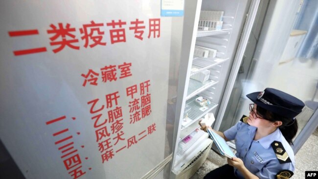 2018年7月23日,当地市场监管机构官员在中国广西荣安一家医院检查疫苗。