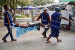 Relawan medis mengangkut seorang demonstran yang terluka akibat tembakan pasukan keamanan dalam aksi protes di Mandalay (foto: dok).