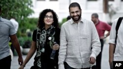 FILE - One of Egypt's most prominent activists, Alaa Abdel-Fattah, walks with his sister Mona Seif before a conference at the American University in Cairo, near Tahrir Square, Egypt, Sept. 22, 2014.