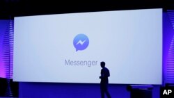 FILE - David Marcus, Facebook Vice President of Messaging Products, watches a display showing new features of Messenger during the keynote address at the F8 Facebook Developer Conference in San Francisco.