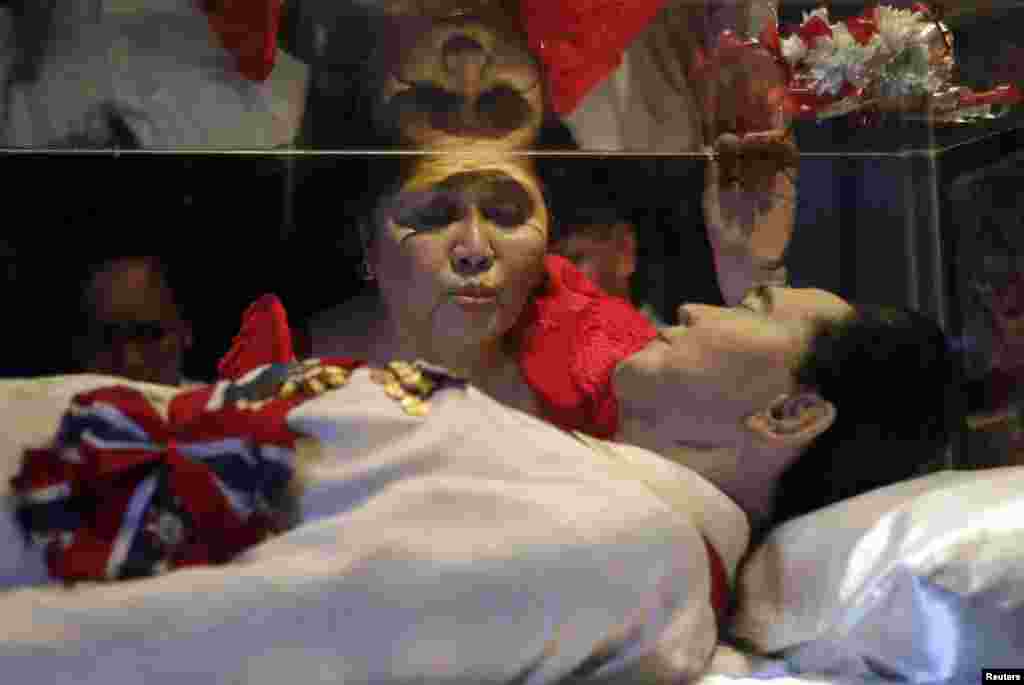 Former First Lady Imelda Marcos kisses the glass coffin of her husband, late President Ferdinand Marcos, who remains unburied since his death in 1989, during her 85th birthday celebration in Ferdinand Marcos&#39; hometown of Batac, Ilocos Norte province, in northern Philippines.
