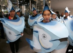 FILE - Greenpeace activists in tuna head costumes gather in front of the Thai Union headquarters in Bangkok, Thailand, June 2, 2017. Greenpeace is campaigning against Thai Union's destructive fishing practices and in favor of improving conditions for fishing industry workers in the global supply chain.