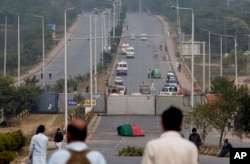 Authorities place shipping containers to stop protesters at an entrance to the capital center following a court decision in favor of a Christian woman in Islamabad, Pakistan, Nov. 1, 2018.