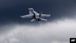 FILE - A F-18 fighter jet flies in display during Farnborough International Airshow, Farnborough, England.