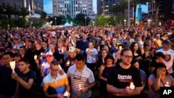 Crowd members hold candles during a vigil downtown for the victims of a mass shooting at the Pulse nightclub Monday, June 13, 2016, in Orlando, Fla. (AP Photo/David Goldman)