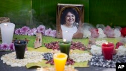 FILE - In this June 15, 2016, file photo, a picture of Berta Caceres sits on an altar in her honor during a demonstration outside Honduras' embassy in Mexico City. 