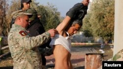 Iraqi army soldiers detain a person suspected of belonging to Islamic State militants during a battle with Islamic State militants in Arabi neighborhood in Mosul, Iraq, Jan. 26, 2017.