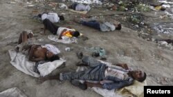 People sleep on the Yamuna river bed under a railway bridge during a hot summer day in the old quarter of Delhi, India, May 31, 2015. Parts of India have experienced 46 degrees Celsius for seven straight days. (REUTERS/Adnan Abidi)