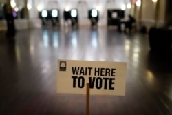 FILE - A sign is displayed for voters to guide the way at a precinct during Georgia's Senate runoff elections, in Atlanta, Jan. 5, 2021.