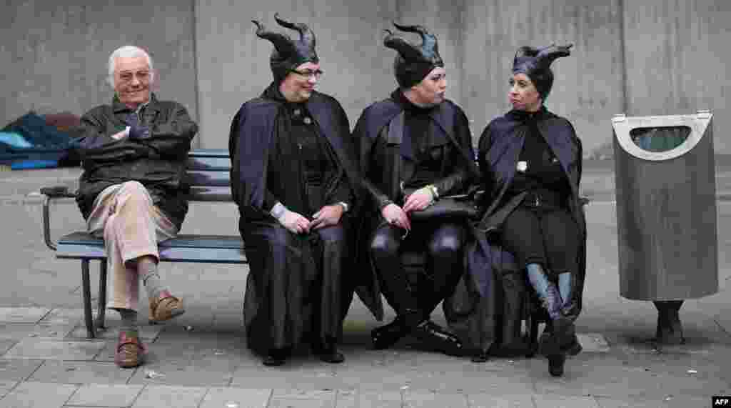 Dressed up woman share a bench with a man during the start of the carnival season in Cologne, western Germany.