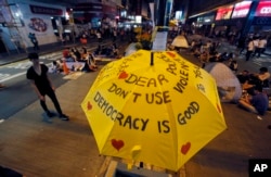 FILE - An umbrella, which has become an icon of the protest, reads pro-democracy messages above the student-led protest site in the Mong Kok district of Hong Kong, Oct. 20, 2014.