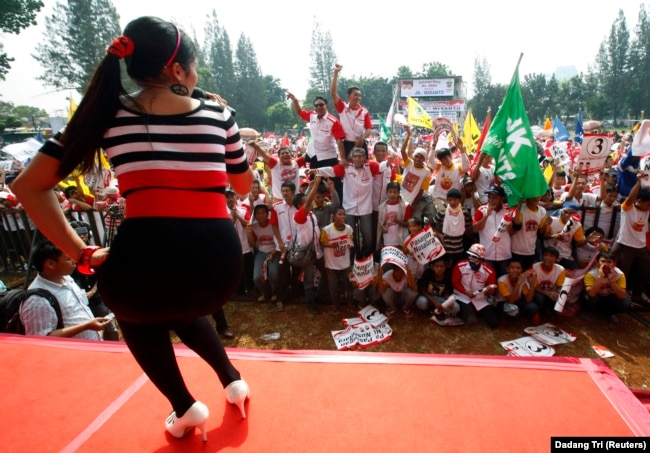 Seorang penyanyi tampil di depan pendukung calon presiden Indonesia Jusuf Kalla dan pasangannya Wiranto, dalam rapat umum kampanye pemilu di Jakarta, 2 Juli 2009. (Foto: REUTERS/Dadang Tri)