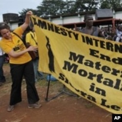 An Amnesty International member unfolds a banner as she prepares for the campaign against maternal deaths in Freetown, Sierra Leone (File Photo)