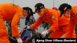 Tim SAR memeriksa sisa-sisa pesawat Sriwijaya Air penerbangan SJ182 yang jatuh ke laut, di pelabuhan Terminal Kontainer Internasional Jakarta, 10 Januari 2021. (Foto: REUTERS/Ajeng Dinar Ulfiana)