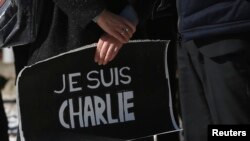 Warga Perancis di Jepang memegang tanda bertuliskan "Saya Charlie" pada penghormatan untuk para korban penembakan di kantor koran Charlie Hebdo di Paris (7/1).