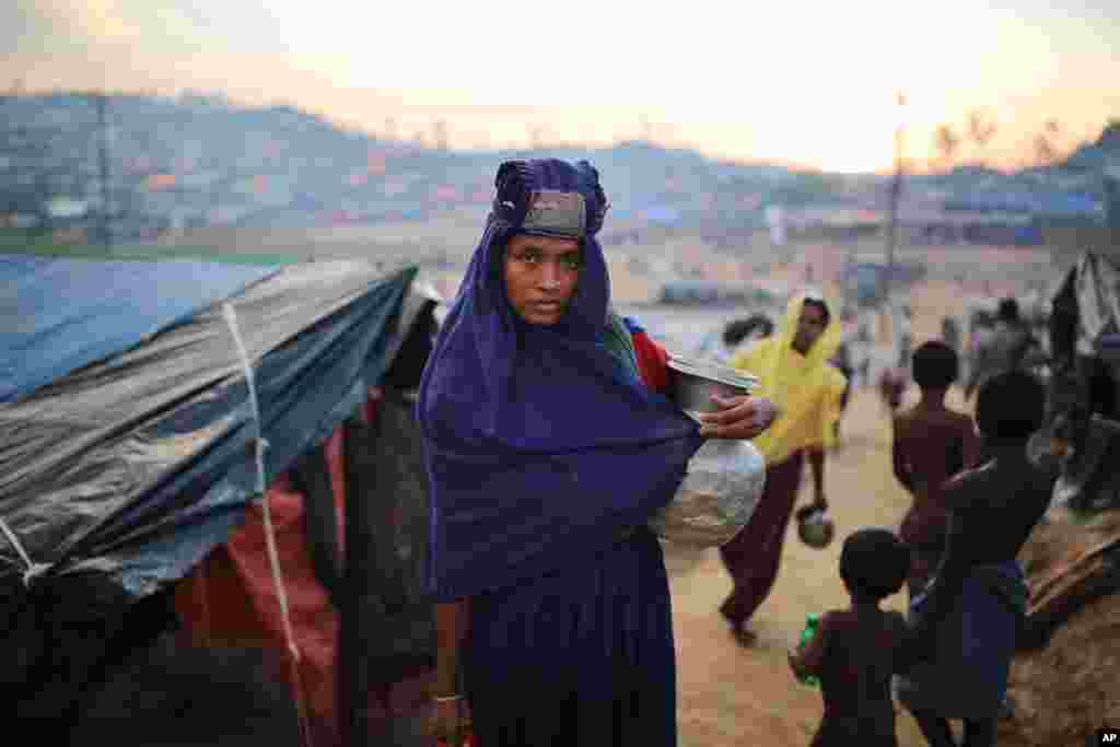 تصویری از زن آواره روهینگیا با گلدانی&nbsp;در دستش برای نوشیدن آب در کمپ پناهندگان در بنگلادش.