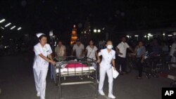 Nurses help pushing a patient's bed as they are evacuated from a hospital building following an earthquake at Chiang Rai hospital in Chiang Rai province, northern Thailand, March 24, 2011