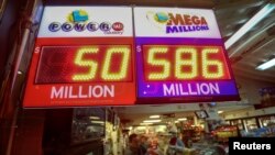 A worker at Nick's Liquor Store sells lottery tickets as a sign shows the Mega Millions jackpot estimated at $586 million in Venice, California, Dec. 16, 2013.
