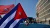 Des Cubains passent devant l'ambassade des États-Unis lors d'un rassemblement appelant à la fin du blocus américain contre leur pays, à La Havane, le 28 mars 2021. 