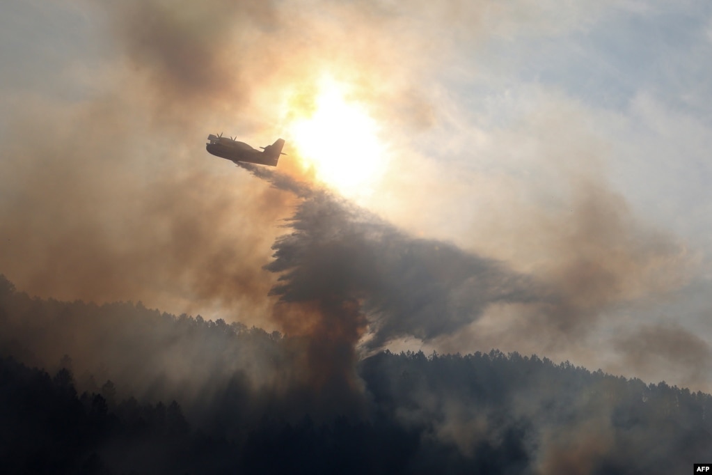 A canadair bomber plane drops water onto a fire along the l'Arone Pass in the Bavella mountains in Quenza on the French Mediterranean island of Corsica. Strong winds from storm Ciara caused wildfires to spread on the island.