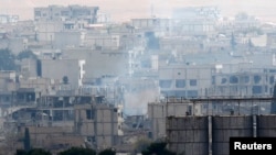 Khói bốc lên từ trung tâm thị trấn Kobani, nơi diễn ra trận chiến ác liệt giữa nhóm Nhà nước Hồi giáo và lực lượng người Kurd. Ảnh chụp từ vùng biên giới Thổ Nhĩ Kỳ và Syria