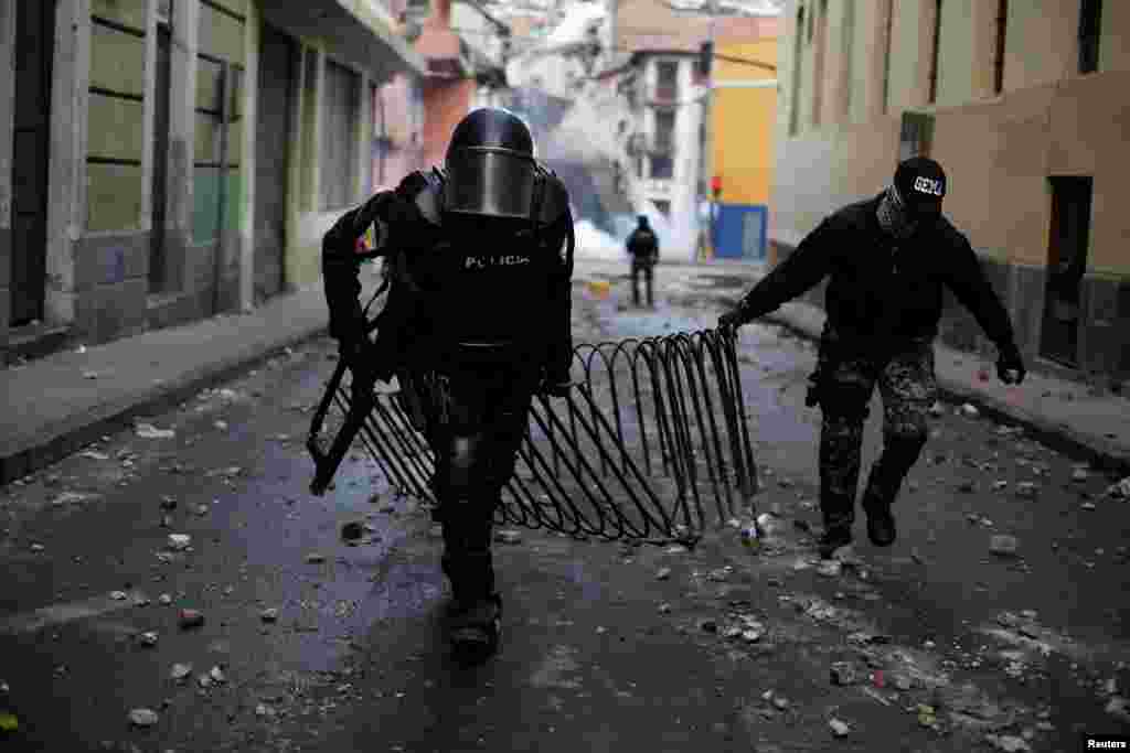 Oficiales de la policía antidisturbios quitan una cerca utilizada por los manifestantes durante las protestas. 