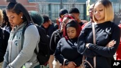 Peace Warriors from North Lawndale College Prep High School bow their heads during a moment of silence for the victims of gun violence during a Day of Peace rally at Chicago's Legacy Charter School, April 20, 2018.