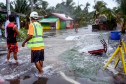 Warga Pagnamitan, Guiuan, Samar Timur, Filipina timur mengamati jalan yang terendam banjir akibat Topan Rai, Kamis, 16 Desember 2021.