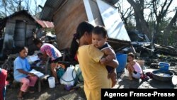 Residents gather next to their destroyed house in Carcar, Philippines, on Dec. 18, 2021, days after Super Typhoon Rai hit the city. (